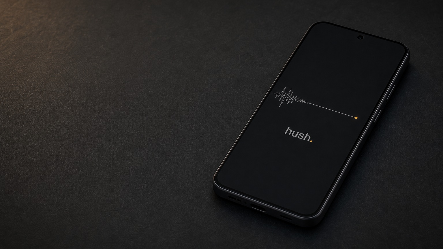 HushPhone på ett mörkt skrivbord, skärmen visar en signalvågform som planar ut till en tyst linje som slutar i en bärnstensgul punkt.